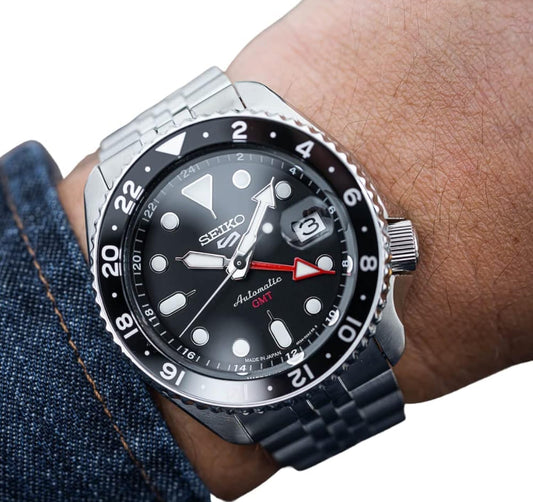SEIKO Outomatiese Horlosie vir Mans - 5 -Sport - Swart Wysplaat met Datumkalender en Liggloeiende Wysers en Merkers en Swart & Grys GMT Ring, 100m Waterbestand