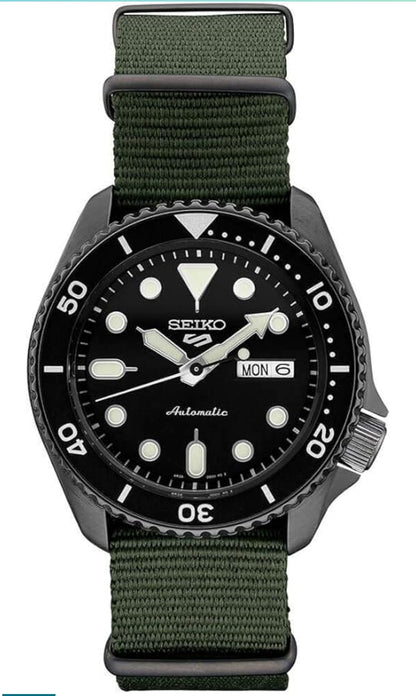 SEIKO Horlosie vir Mans - 5 Sports - Outomaties met Handopwen-beweging, Swart Skakelaar met Swart Ring, Swart Ioon-vlekvrye staal-kas, Groen Nylon Band, en Dag/Datum-vertoning